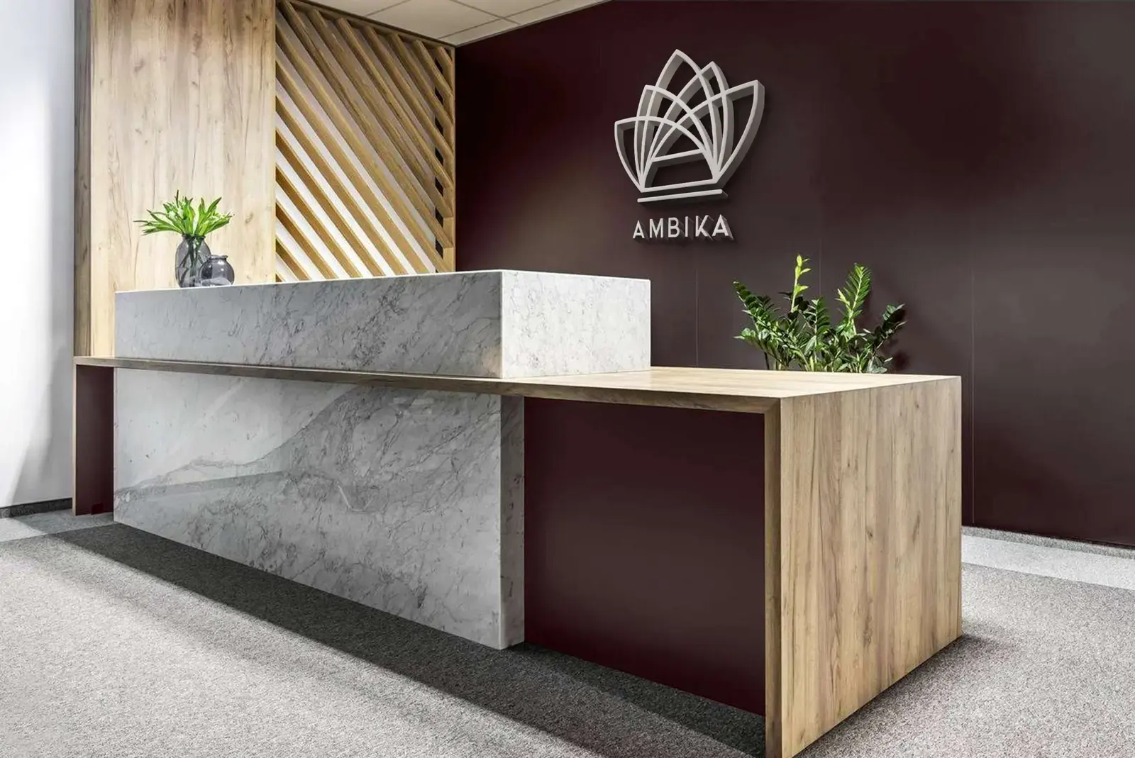 Ambika emblem mounted behind a stone and timber restaurant reception desk