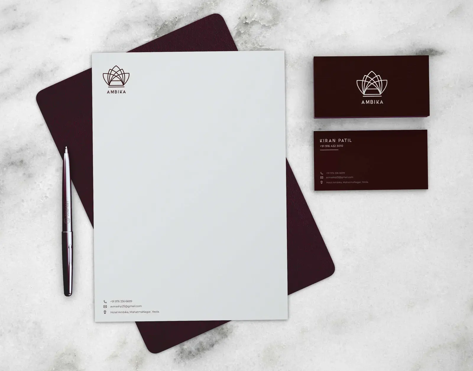 Ambika letterhead and business cards arranged on pale stone