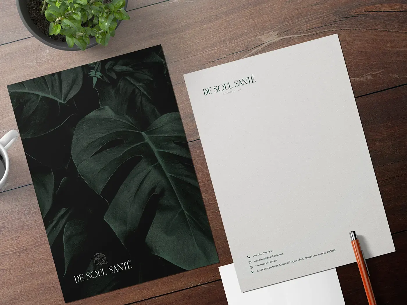 De Soul Santé letterhead and botanical stationery on a wooden desk