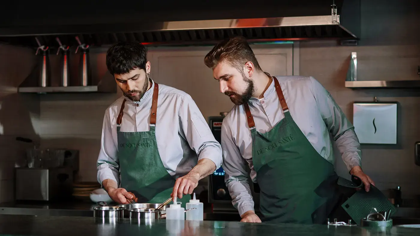 Hospitality staff wearing De Soul Santé green aprons