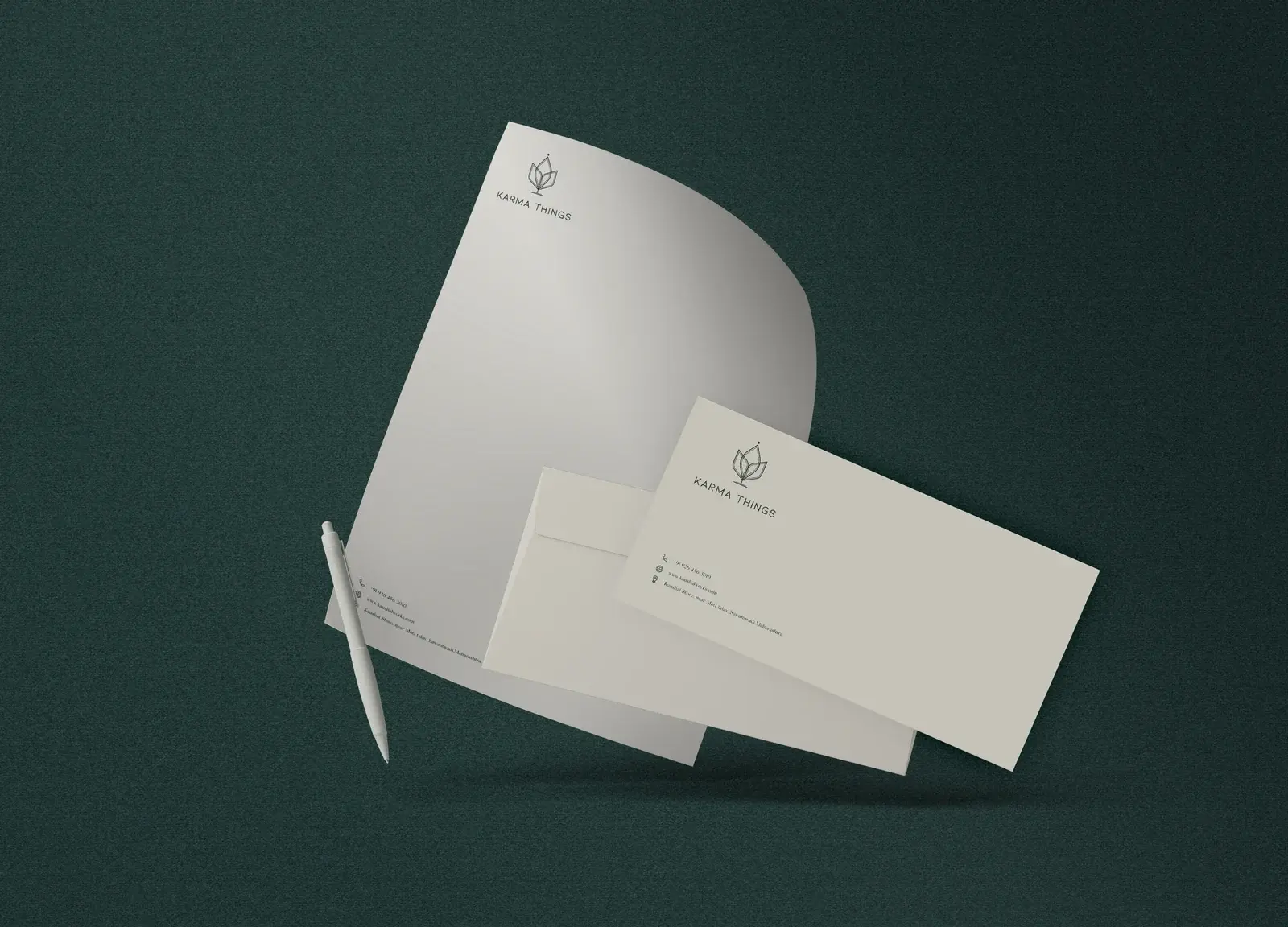 Karma Things letterhead, envelope and business card on a deep-green surface