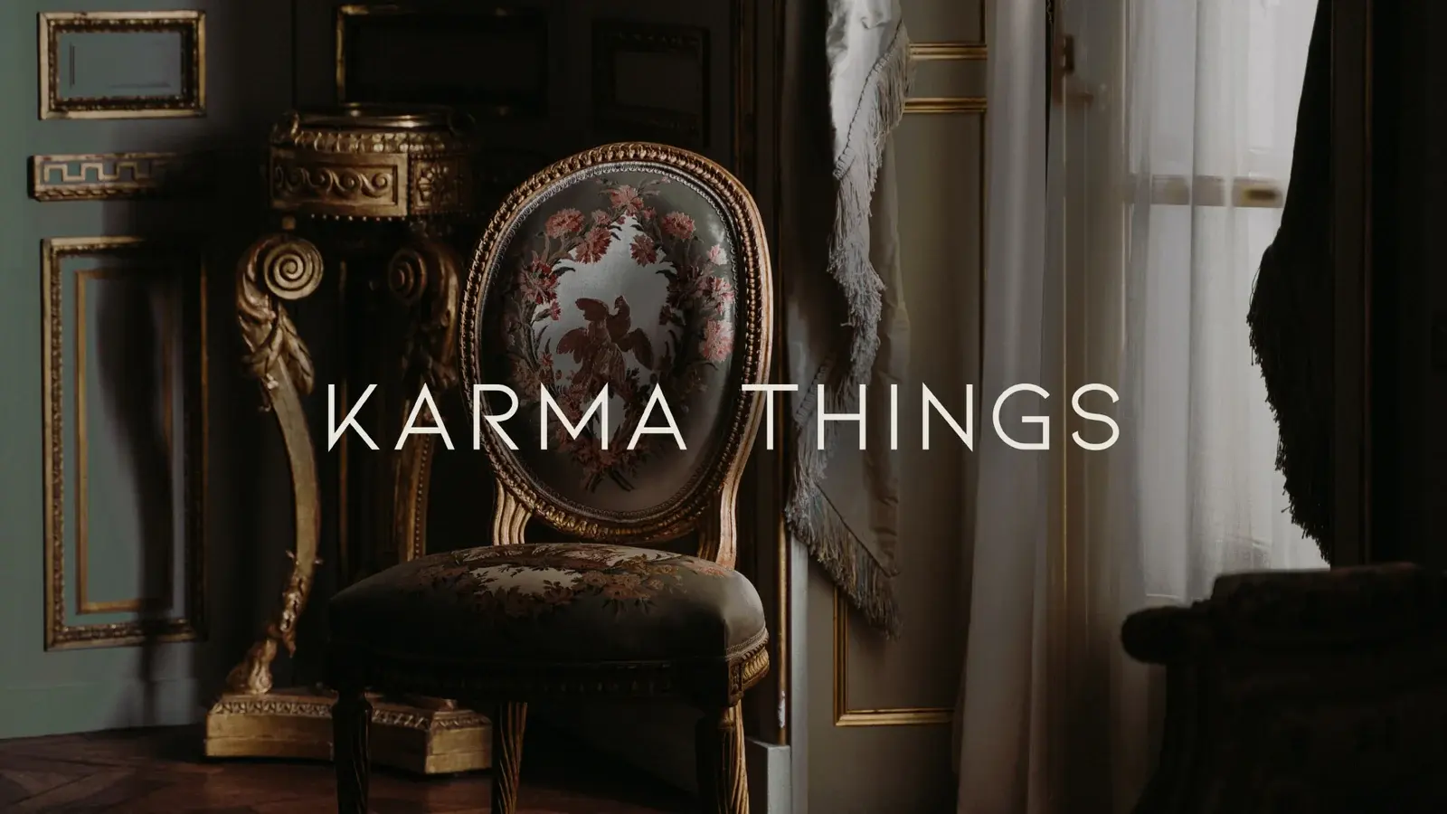 Karma Things wordmark over an ornate chair in a dark heritage interior